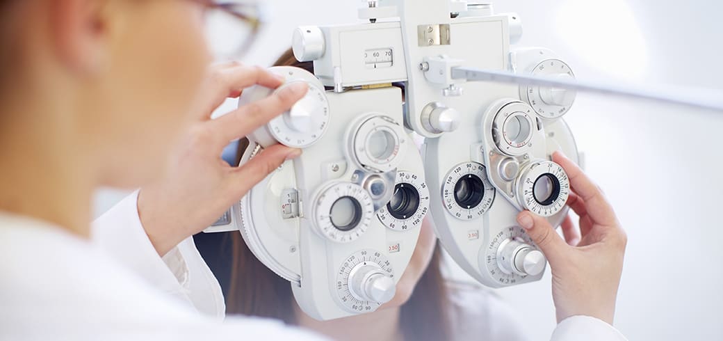 Imaginea unui optician care instalează un aparat de testare a ochilor.